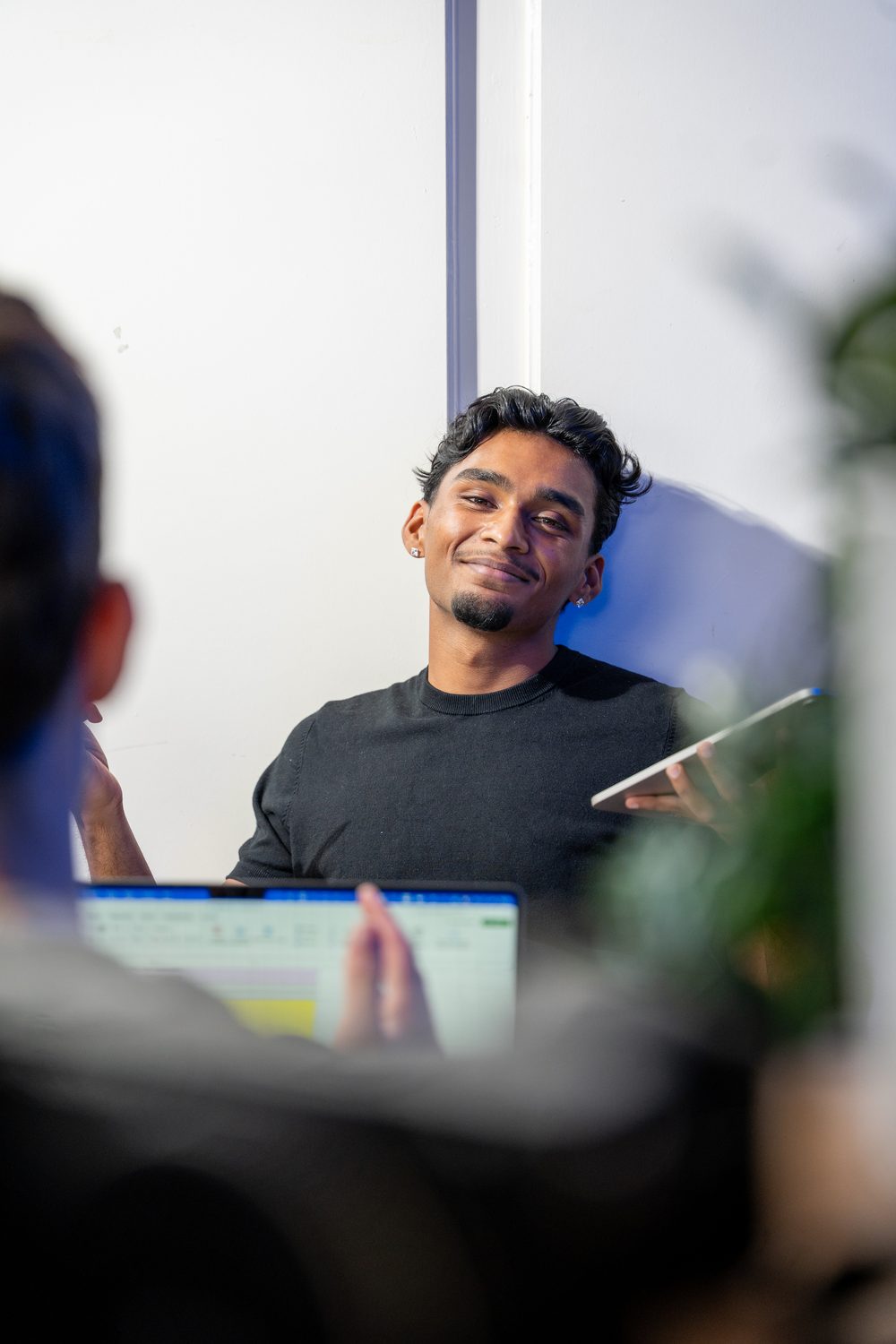 Rojith Ragavan lacht mit Tablet im Büro