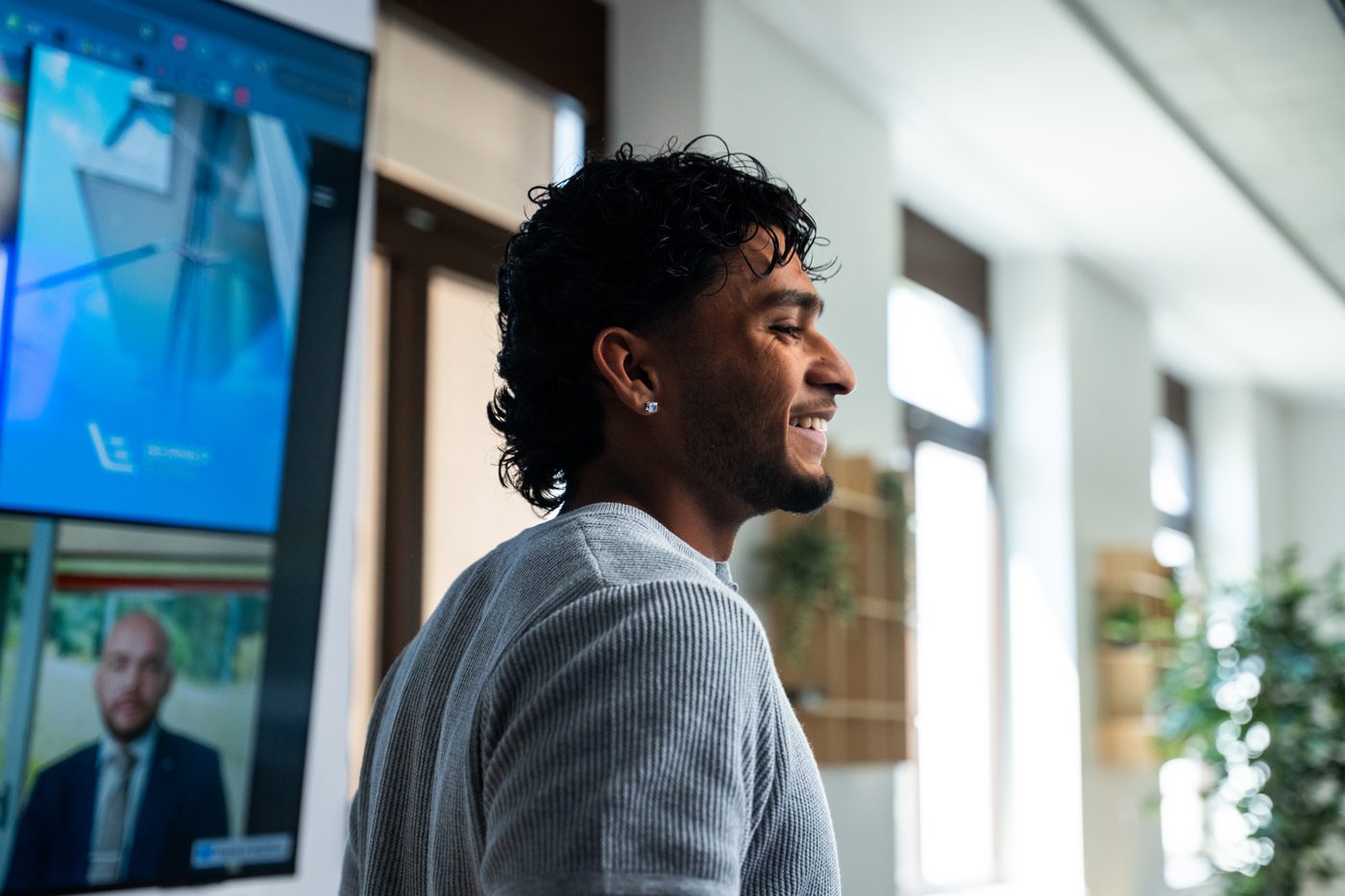 Rojith Ragavan lacht vor der Videowand im Haldelain-Loft